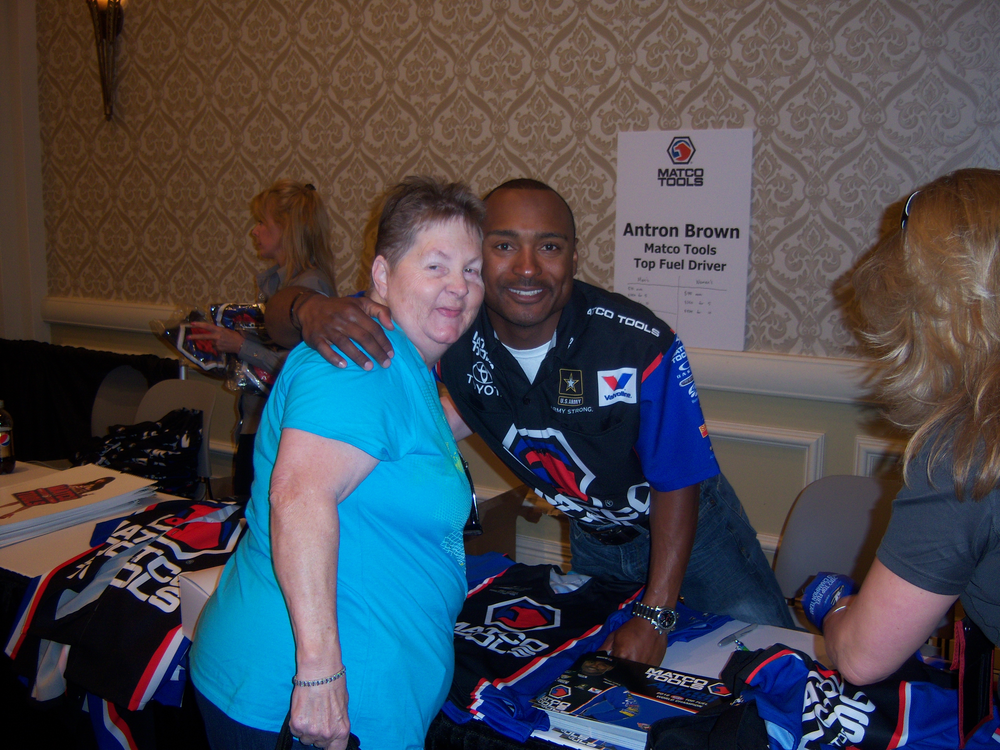 Matco Tools Top Fuel Driver Anton Brown signs t-shirts and greets attendees at the trade show.