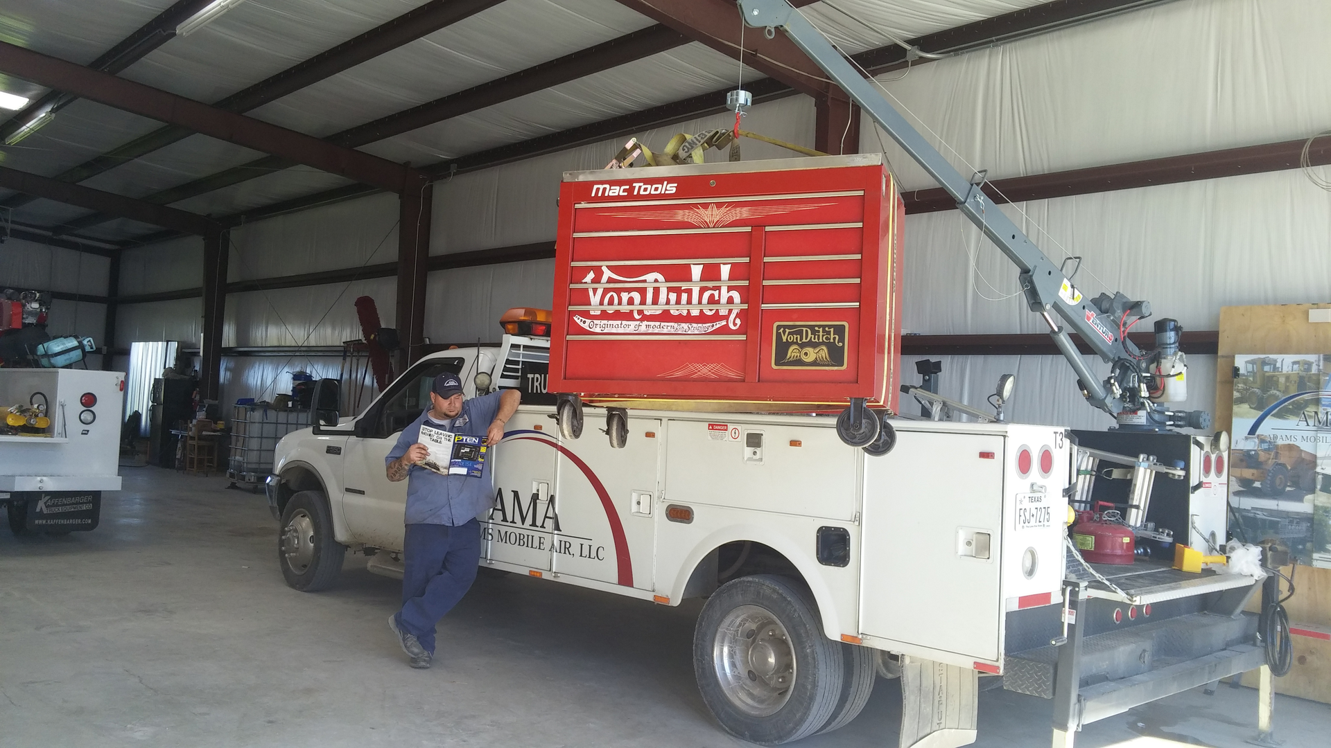 Carl Adams reads a copy of PTEN magazine near his T3 toolbox truck outfitted with a crane, the longest truck in the company's fleet.