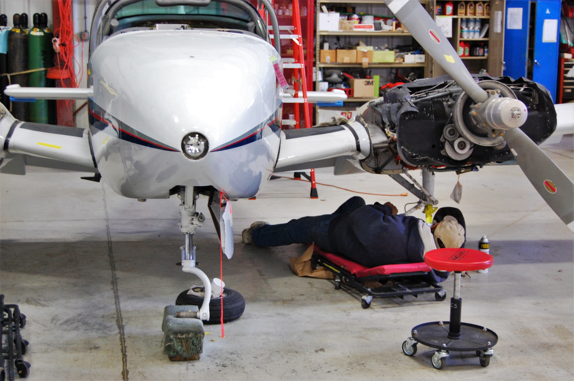 Like automotive technicians, aircraft technicians utilize adjustable creepers and stools on the job. Pictured here: A Wisconsin Aviation technician on the Whiteside MTL2UP 40' Either End Adjustable Creeper