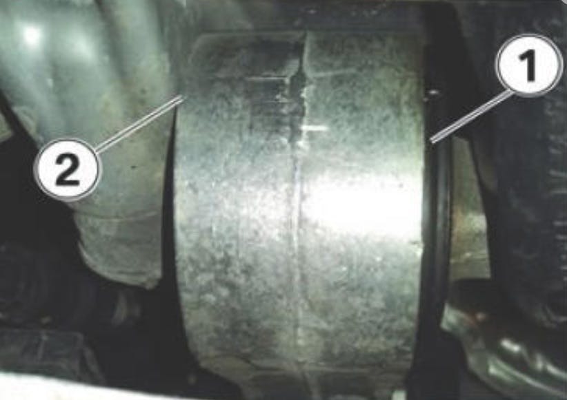 If the link bushing is working its way out, the aluminum link housing (1) may start to rub against the oil pan (2).