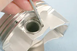 Installing a wire clip. Notches at the pin bore edge provide access for a small tool to guide the clip into place. The clip engages into a groove near the end of the pin bore. Installing a wire clip. Notches at the pin bore edge provide access for a small tool to guide the clip into place. The clip engages into a groove near the end of the pin bore.