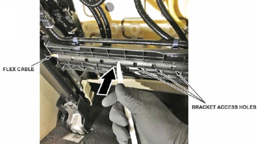 Use a trim tool to release the cable from the plastic bracket.
