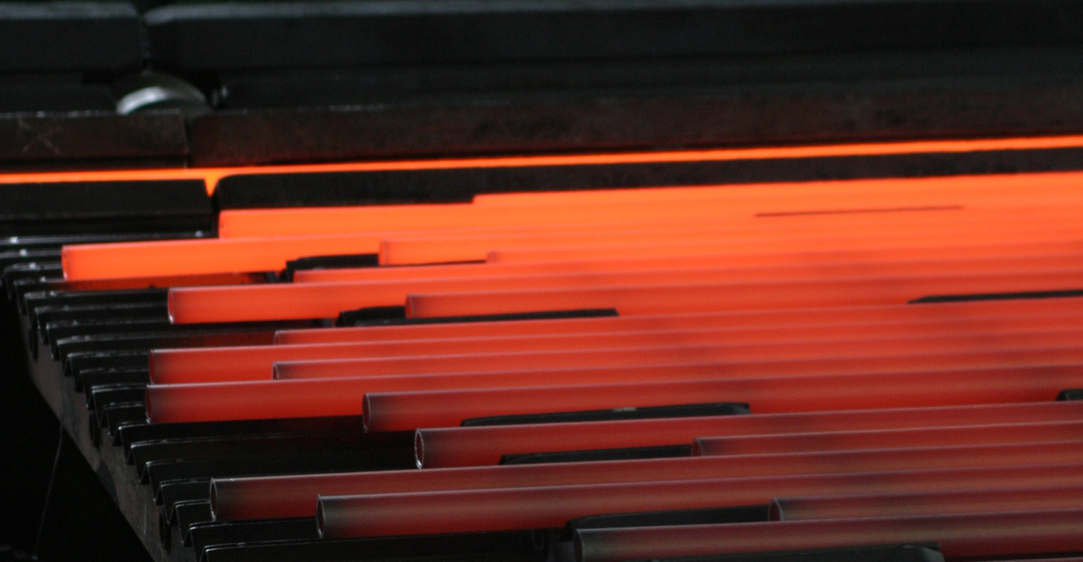 Hot steel long products on a walking cooling bed.