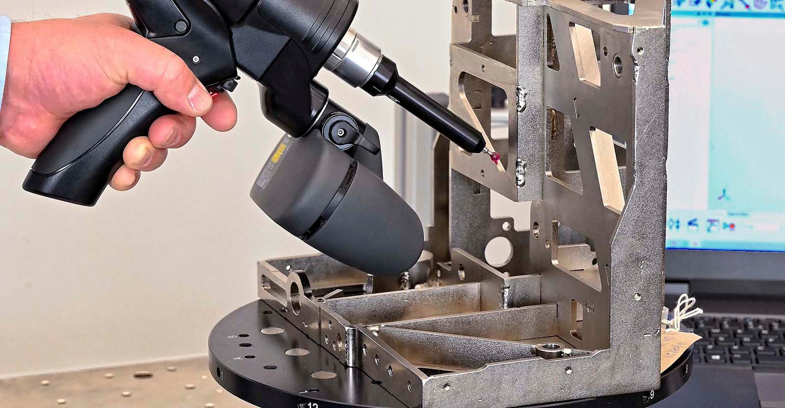 Mounted on a mobile workstation, LK Metrology's new Freedom index table being used to speed the inspection of an assembly using an LK portable measuring arm of the same name.