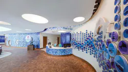 A curved mosaic feature wall is illuminated with LED PAR20 lamps in the children’s hospital lobby. A curved mosaic feature wall is illuminated with LED PAR20 lamps in the children’s hospital lobby.