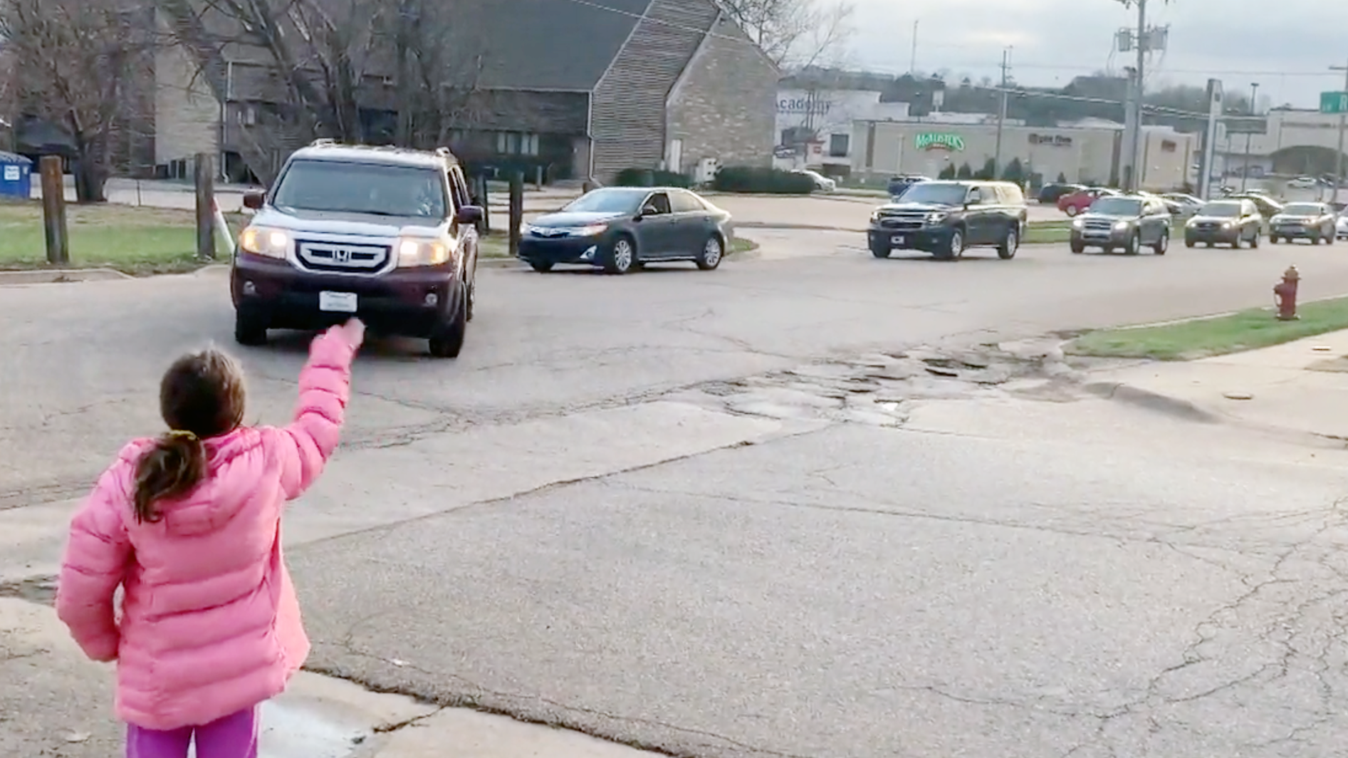 Staff members drive a parade of cars through the Wanamaker Elementary School neighborhood to keep in touch with students from a safe distance.