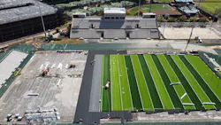 Workers install turf for the new football field at Ching Stadium Workers install turf for the new football field at Ching Stadium