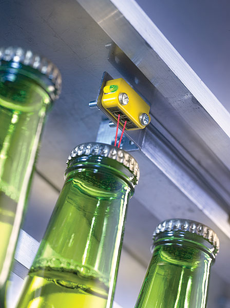 This photoelectric sensor inspects for the presence of bottle caps.