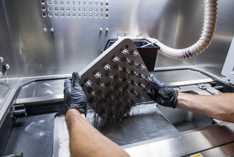 Removing a DMLS print from the powder.