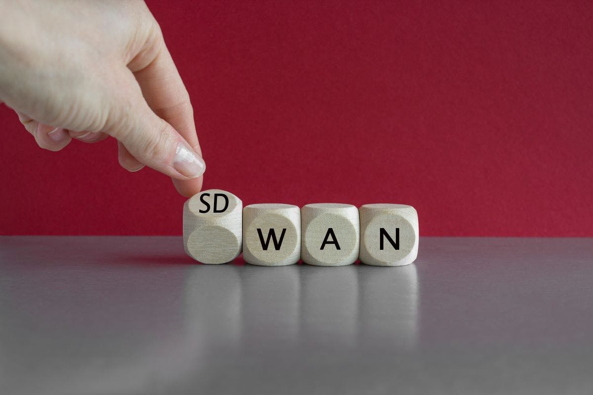 Hand turned a dice and form the expression SD WAN. Symbol for Software defined Wide Area Networking.