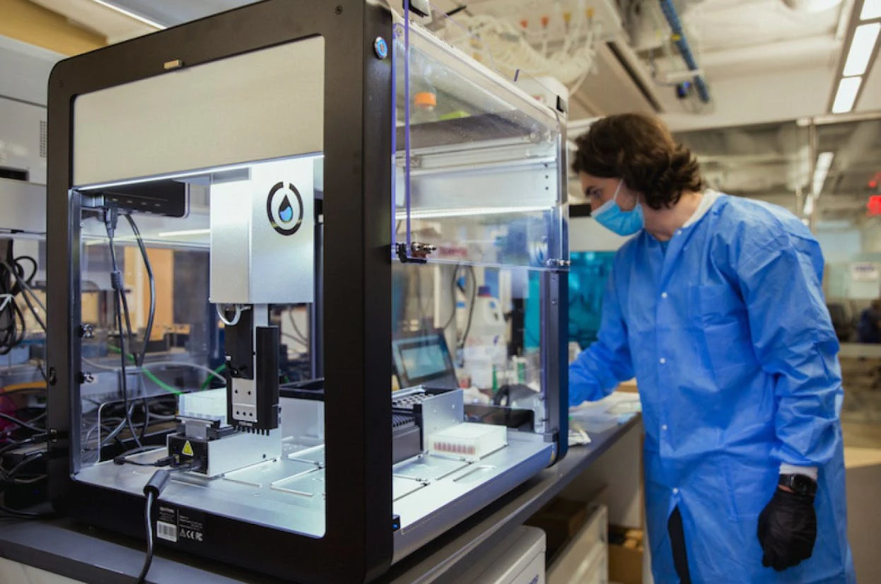 lab technician working with Opentrons system.