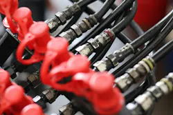 Close up of industrial hydraulic hoses with connectors and red protective dust caps, professional fluid power system for heavy machinery engineering and maintenance. Close up of industrial hydraulic hoses with connectors and red protective dust caps, professional fluid power system for heavy machinery engineering and maintenance.