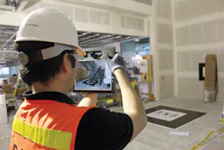 A crew member uses a ruggedized tablet equipped with augmented reality software to visualize the BIM geometry of a complex stai A crew member uses a ruggedized tablet equipped with augmented reality software to visualize the BIM geometry of a complex stai