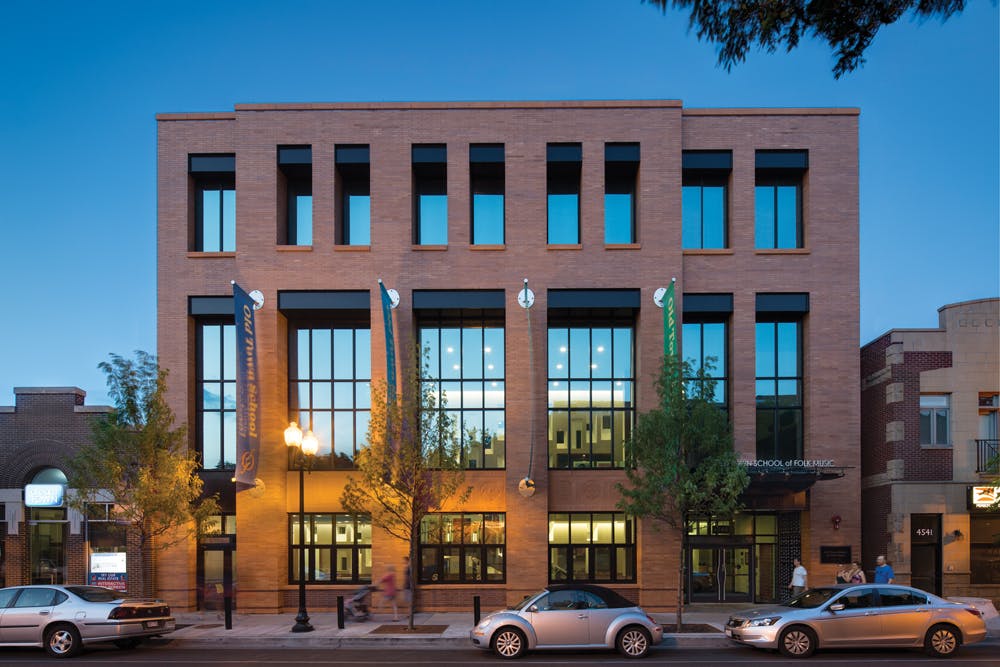 Vertical Elements And Orange Brick On The Old Town Schools New East Building Evoke The Faade Of The Clients Headquarters Across The Street, Which Was Created Through Adaptive Reuse Of An Art Deco Library Precast Concrete Panels Interpret The Word Music In Ancient And Modern Languages