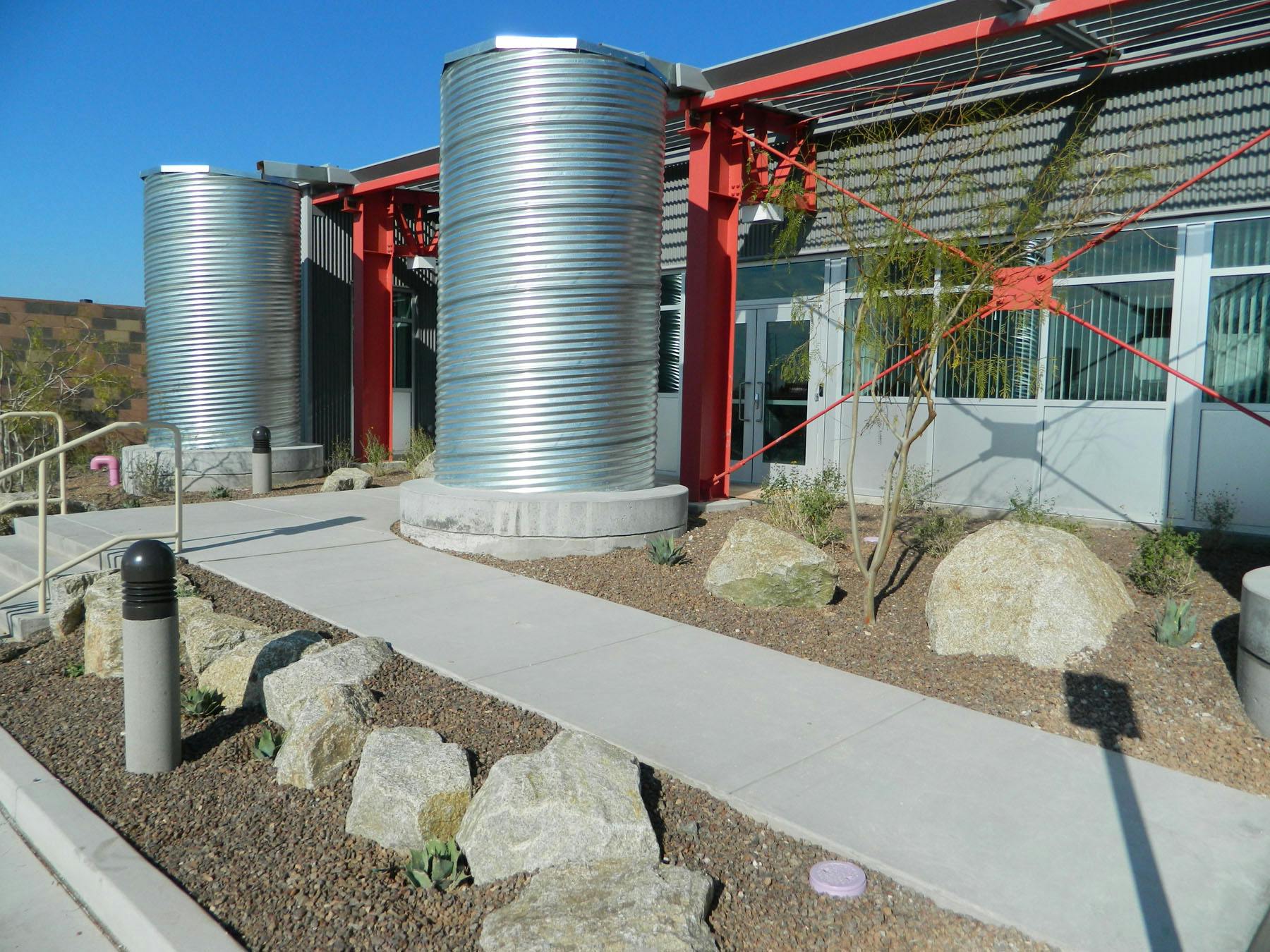 A single-slope metal roof supports an efficient rainwater harvesting system. Twelve galvanized steel cistern tanks gather water