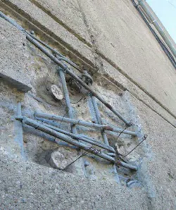 Cut and chipped concrete with exposed rebar and anodes Cut and chipped concrete with exposed rebar and anodes