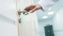 cropped view of male doctor holding door handle in hospital cropped view of male doctor holding door handle in hospital
