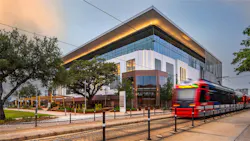A train on the railway tracks in front of adaptive reuse building A train on the railway tracks in front of adaptive reuse building