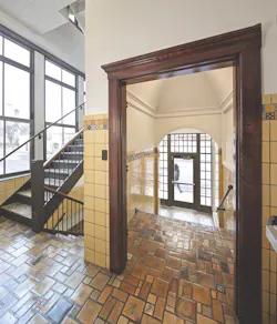 The entry vestibule and stairs with period floor tiles and wainscoting The entry vestibule and stairs with period floor tiles and wainscoting