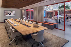 The ebullience of the café bar and lounge beams through double pane glass walls of adjacent meeting rooms. Photo by SLAM The ebullience of the café bar and lounge beams through double pane glass walls of adjacent meeting rooms. Photo by SLAM