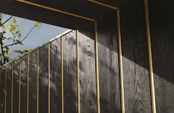Gold metallic band between vertical siding boards Gold metallic band between vertical siding boards