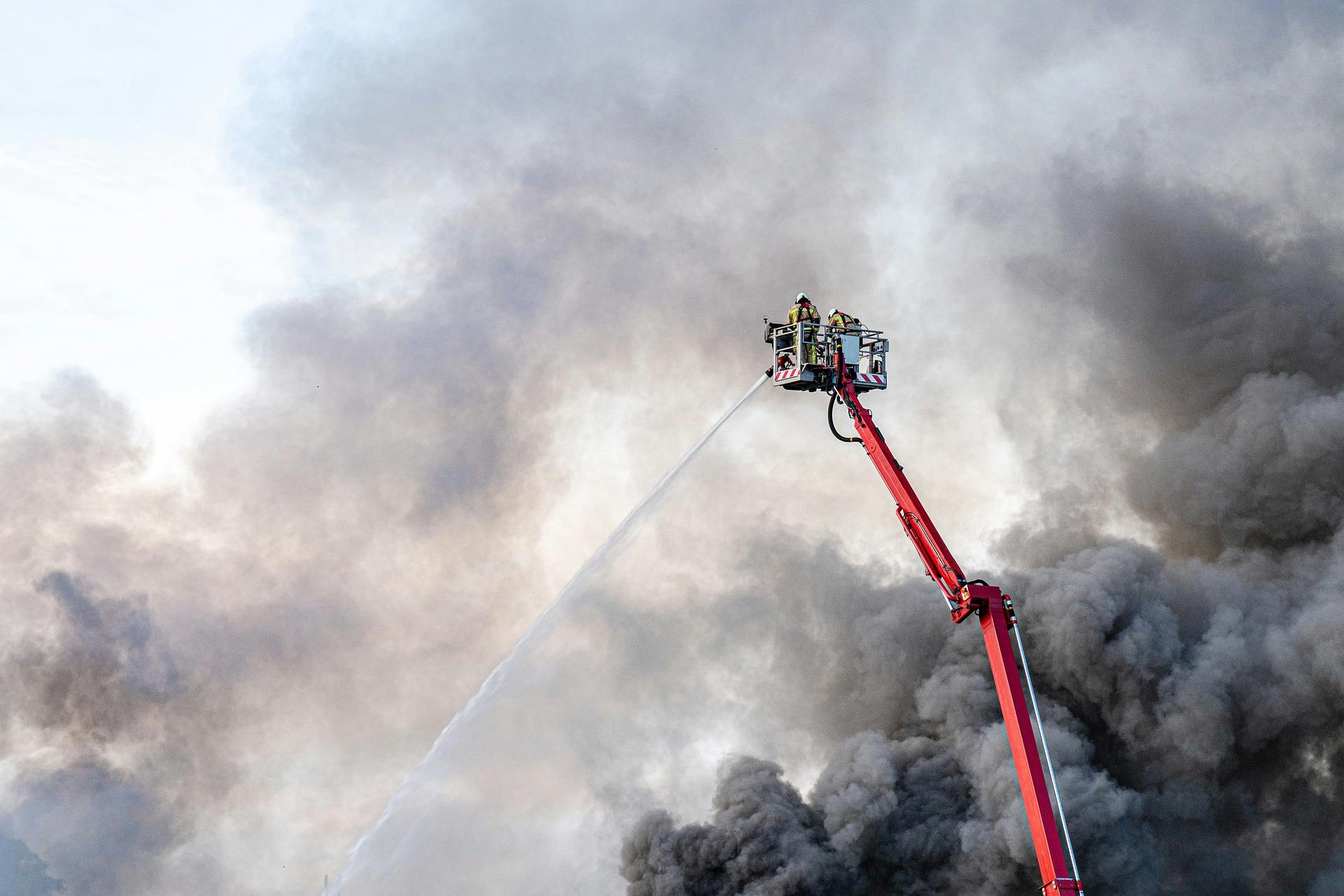 Fireman fighting fire with water hose