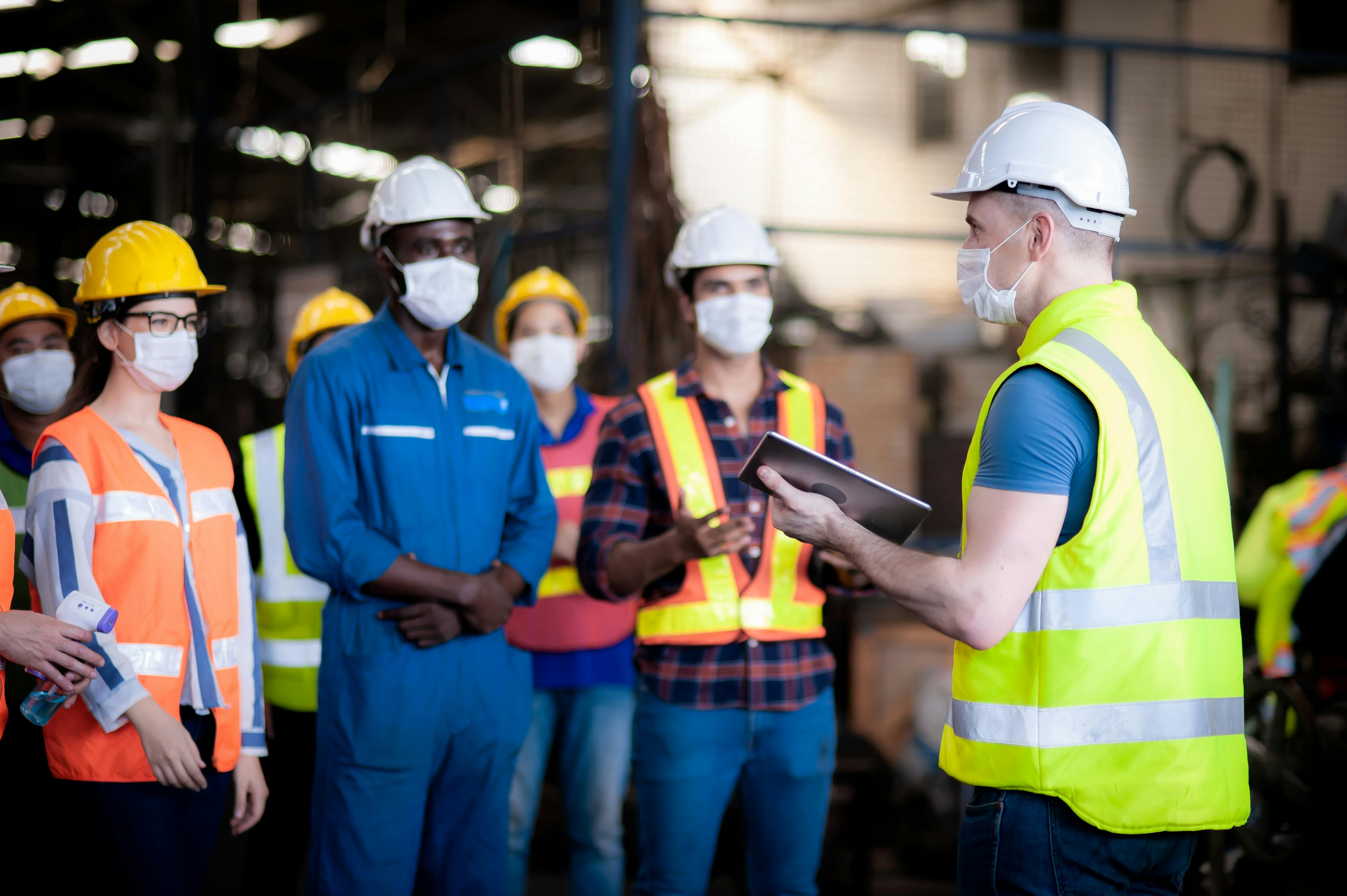 The manager or leader team is assignmenting a job for team of technicians, supervisor, foreman and engineers In the morning meeting before work In which everyone wear masks to prevent the coronavirus