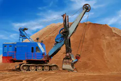 Heavy electric excavator in sandpit. Heavy digger electric excavator standing in sandpit with huge bucket on the ground Heavy electric excavator in sandpit. Heavy digger electric excavator standing in sandpit with huge bucket on the ground