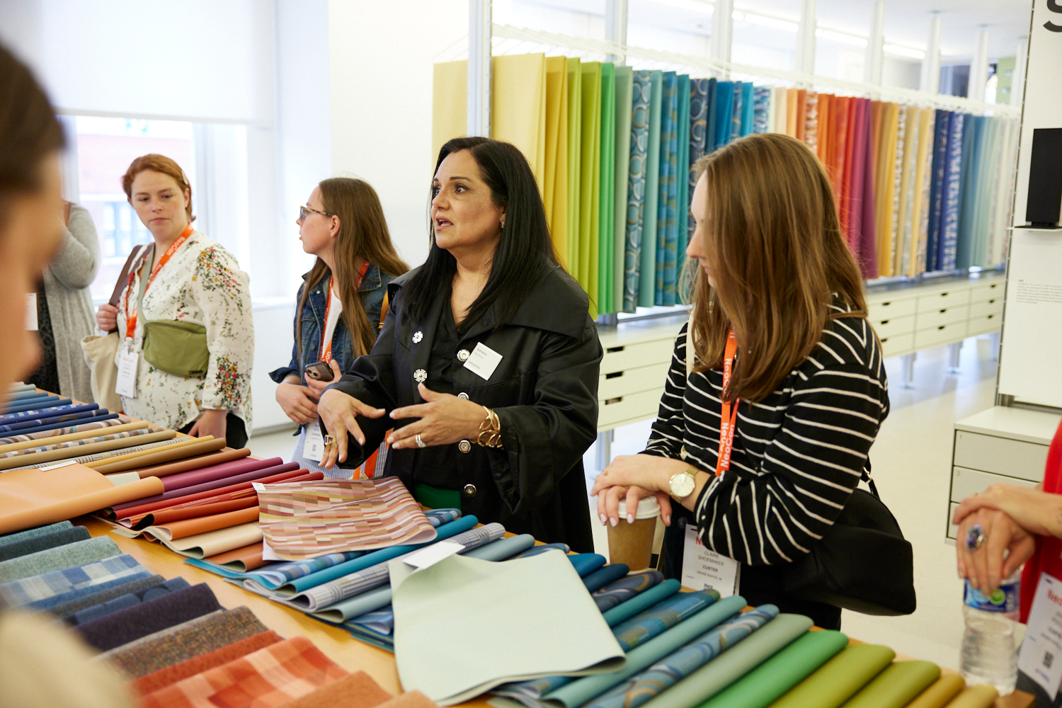 Visitors to this NeoCon showroom examine textiles. The 2023 show embodied its theme, &ldquo;Together We Design.&rdquo;