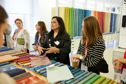 Visitors to this NeoCon showroom examine textiles. The 2023 show embodied its theme, “Together We Design.” Visitors to this NeoCon showroom examine textiles. The 2023 show embodied its theme, “Together We Design.”