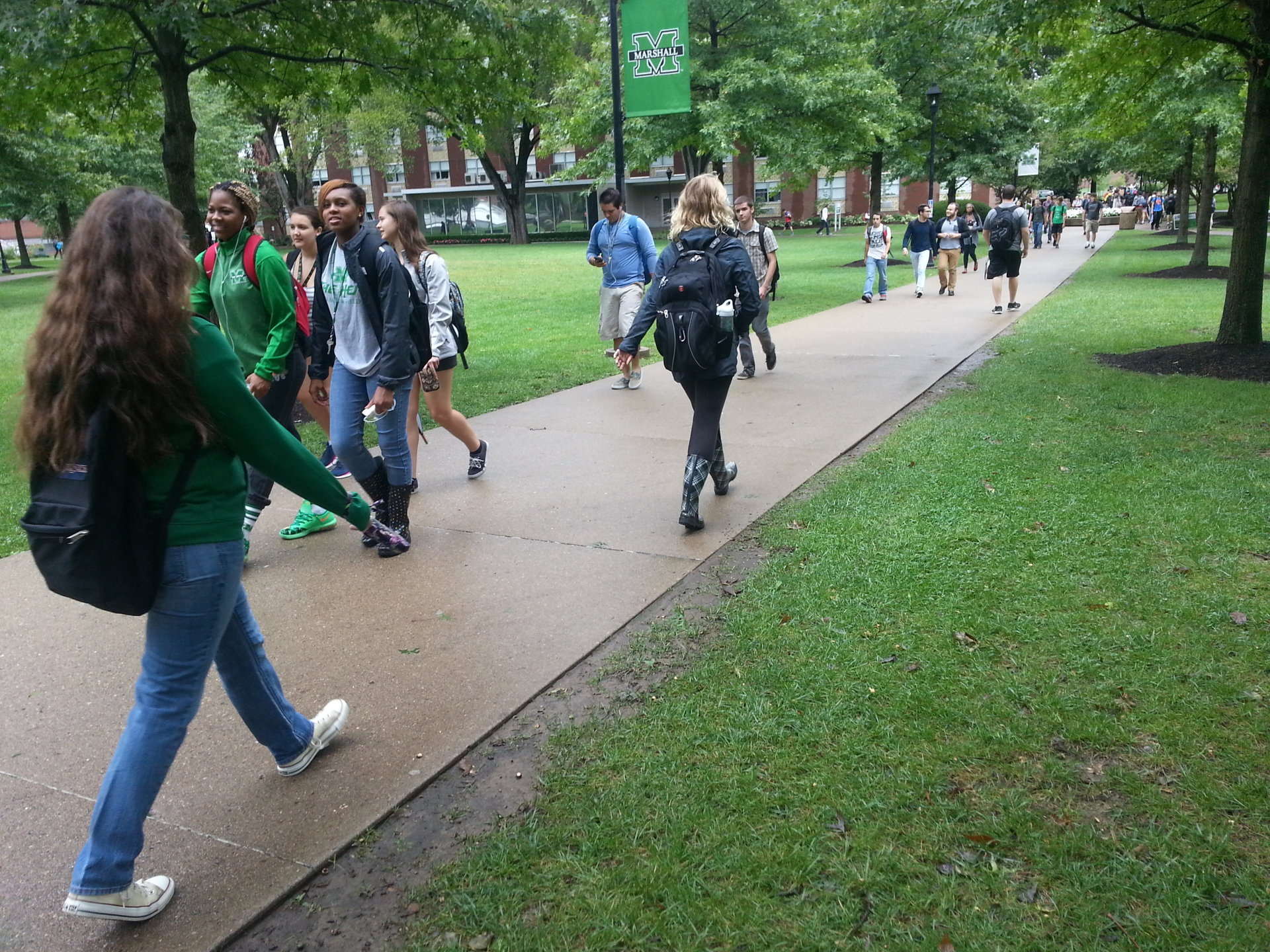 College students use a sidewalk to move through campus.