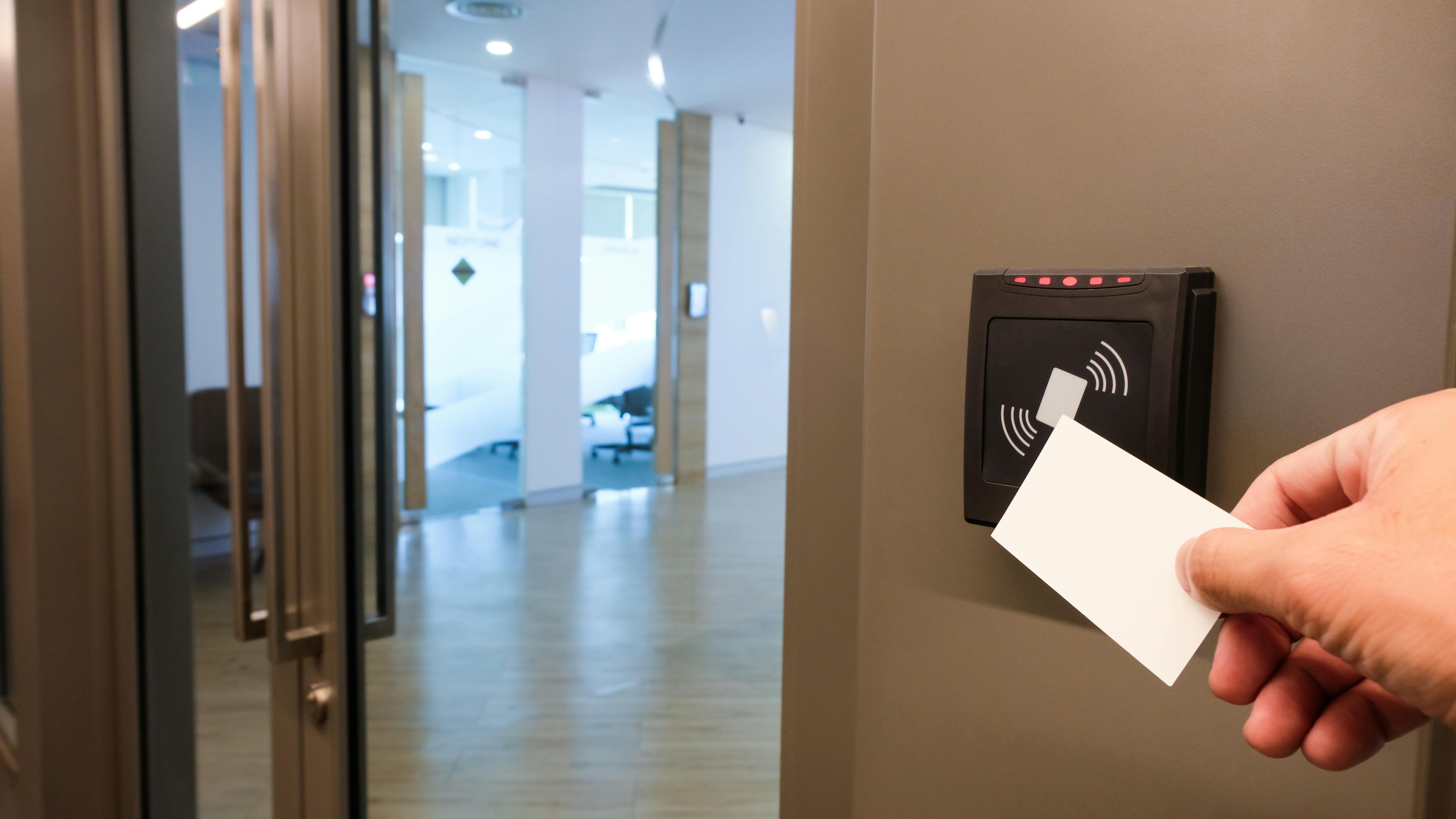 An employee uses a key card to access a workspace.