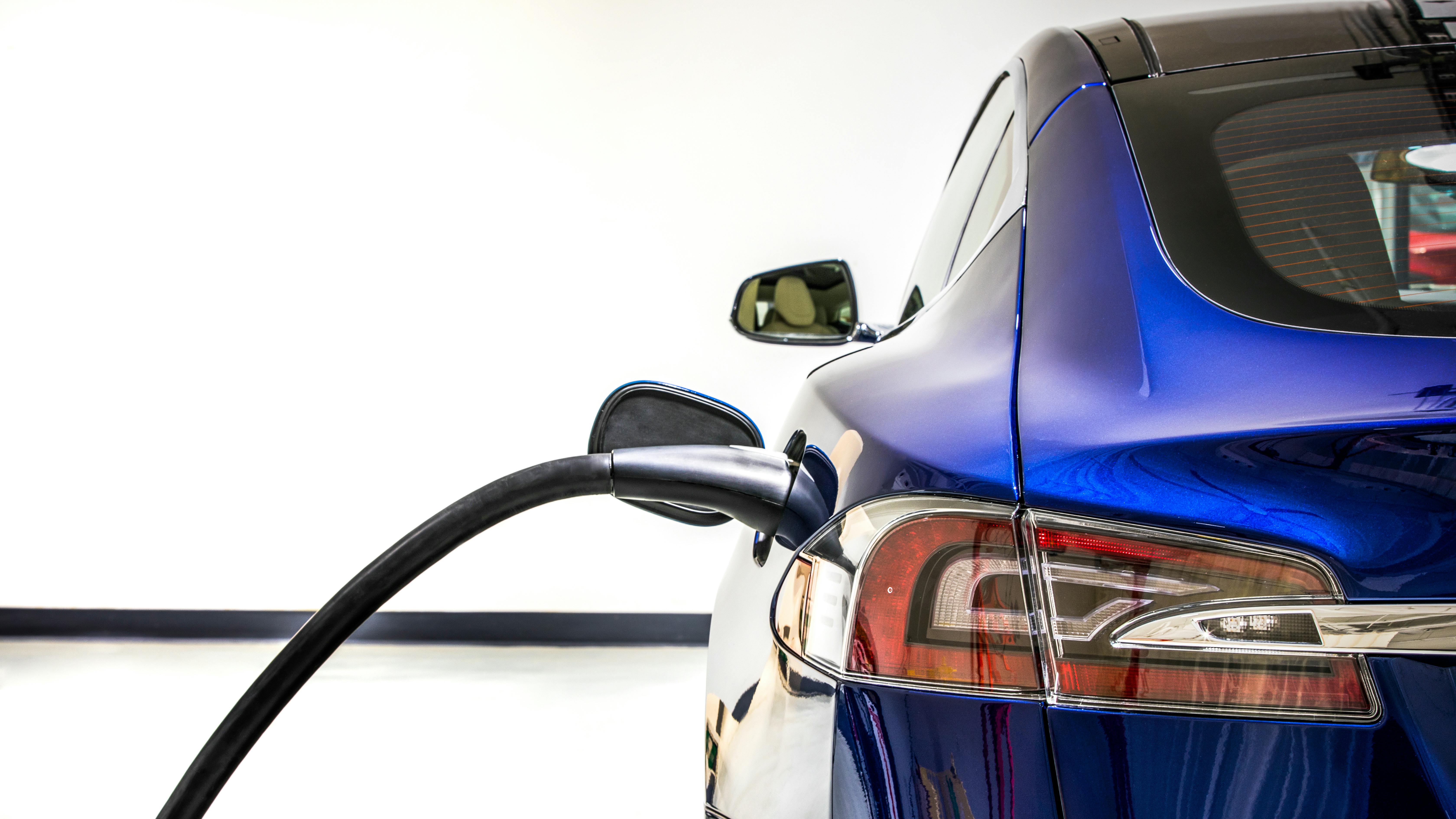 An electric vehicle charges at a charging station.