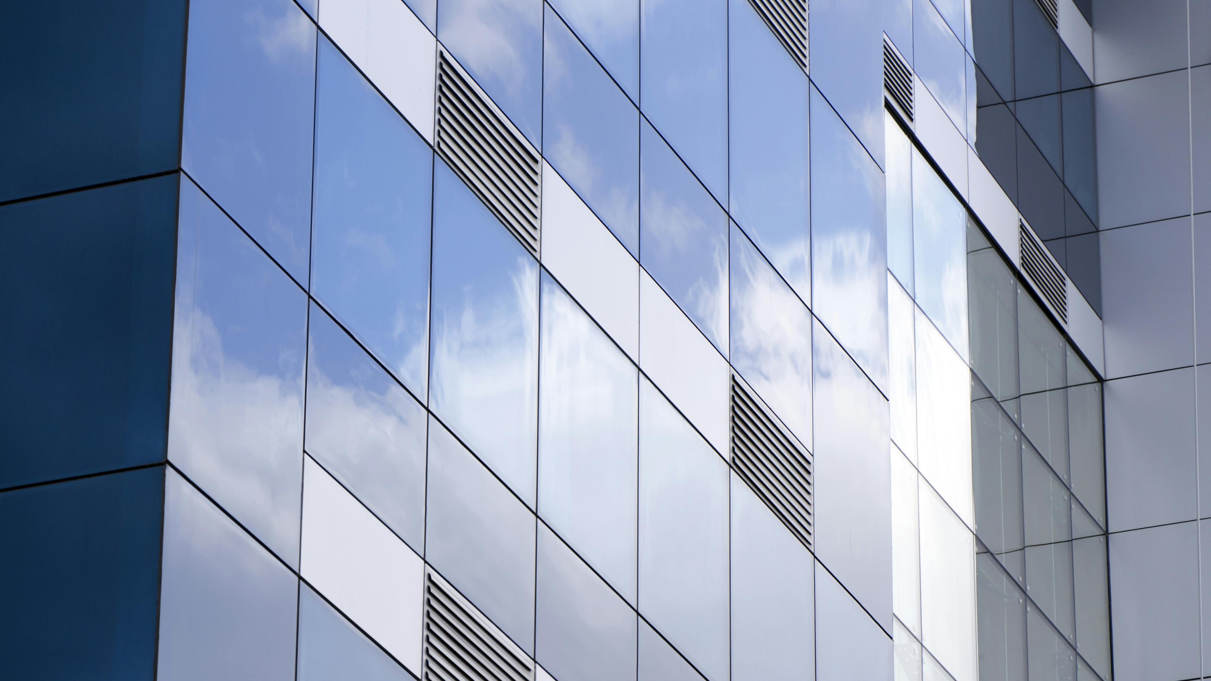 Exterior of modern glass building with ventilation grates.