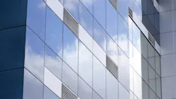Exterior of modern glass building with ventilation grates. Exterior of modern glass building with ventilation grates.