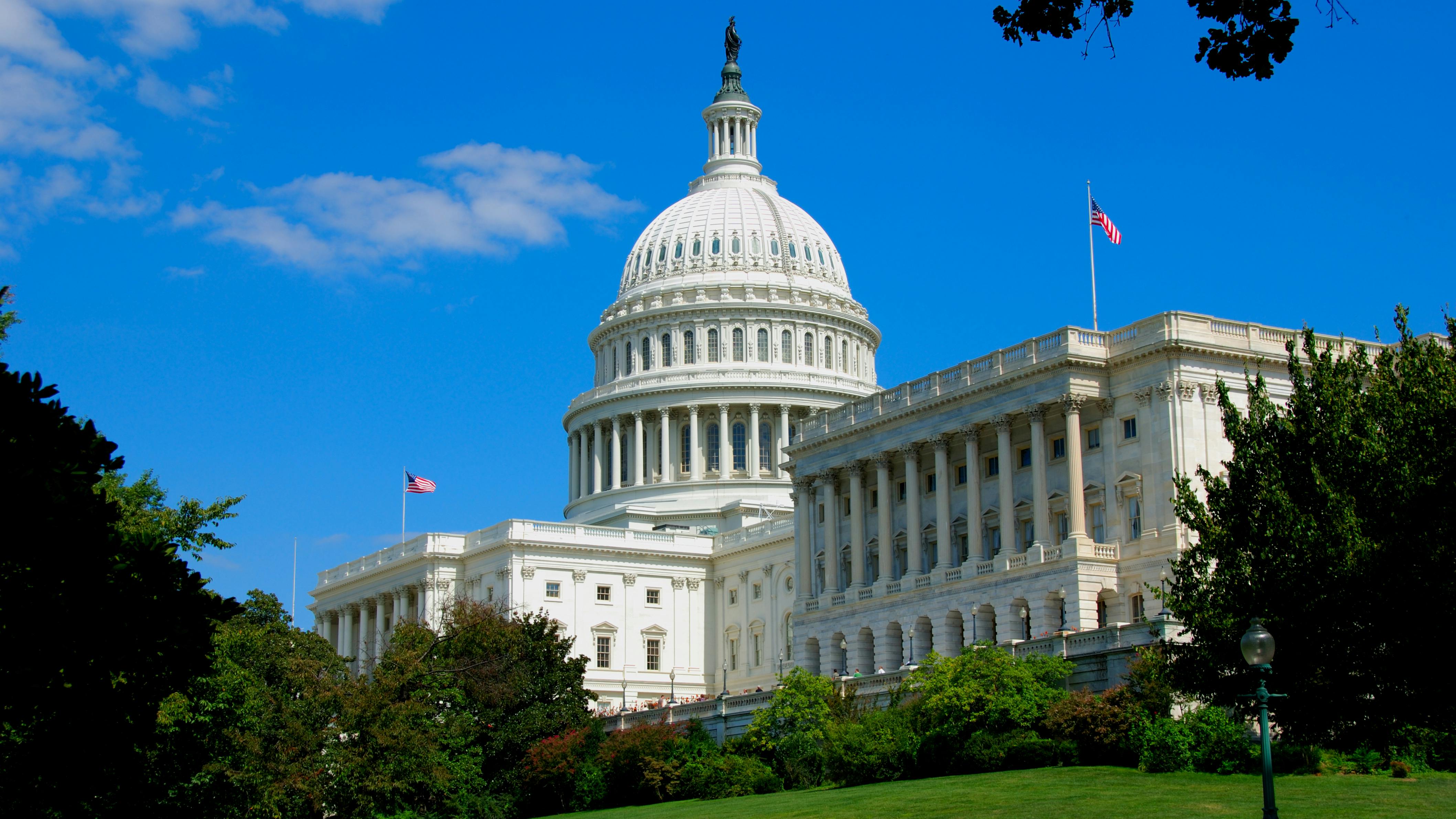 U.S Capitol building with lawn in foreground and clear, blue sky in background.