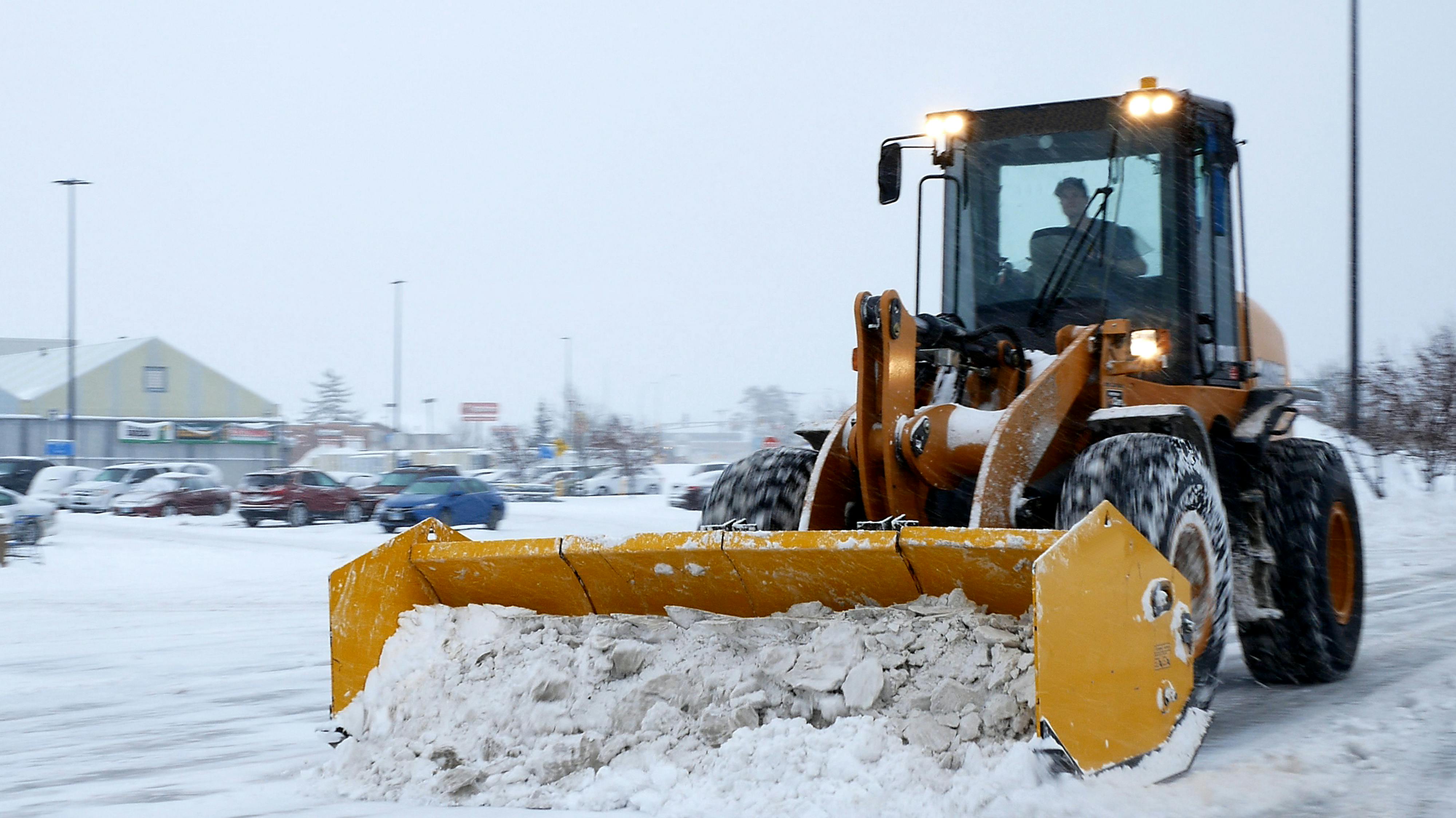A snowplow clears a parking lot during a storm in Bemidji, Minnesota.