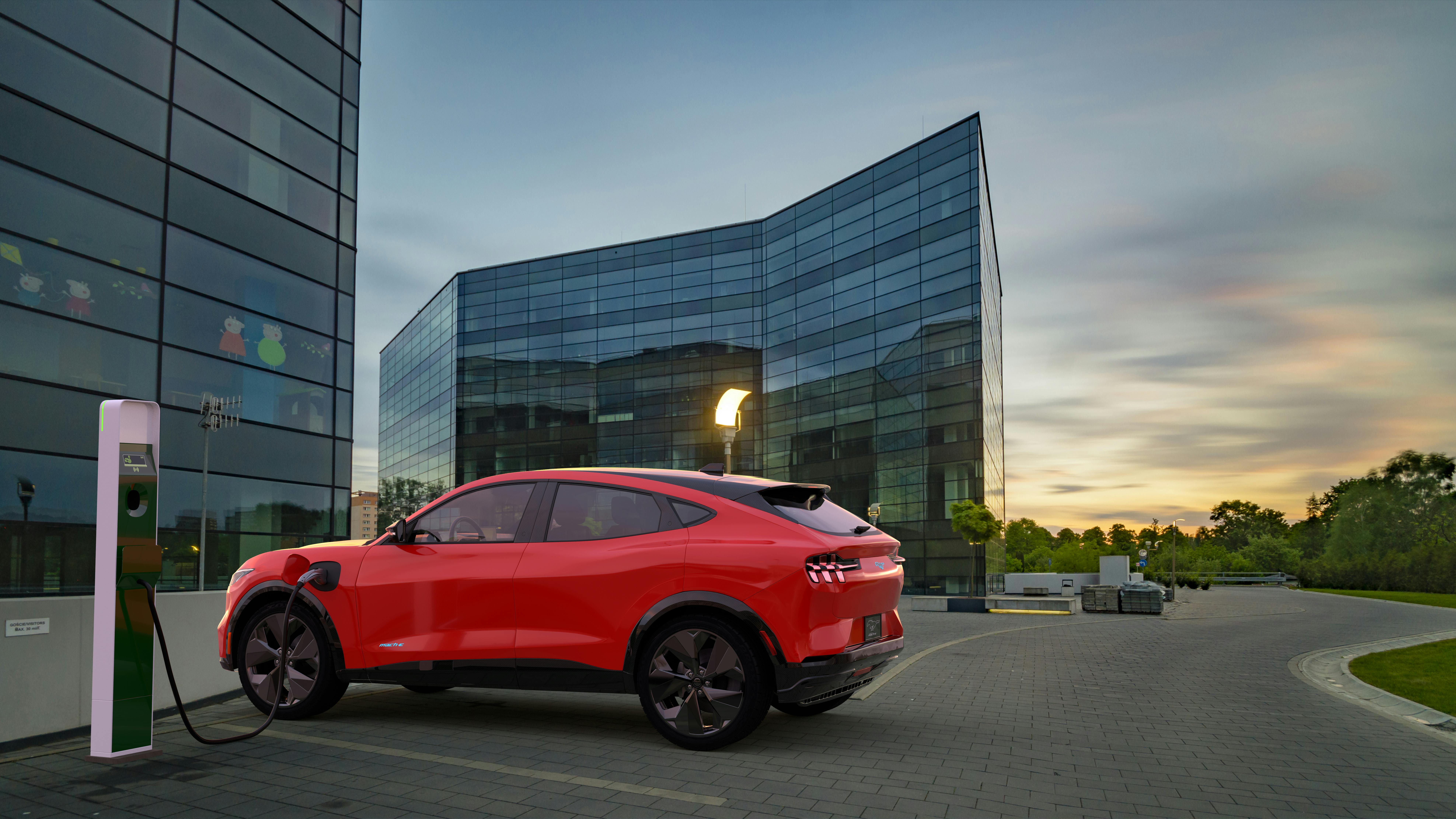 Ford Mustang Mach-E, All-Electric SUV on the charging station outside commercial building at dusk