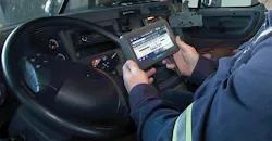Closeup of driver holding ELD in cab of truck Closeup of driver holding ELD in cab of truck