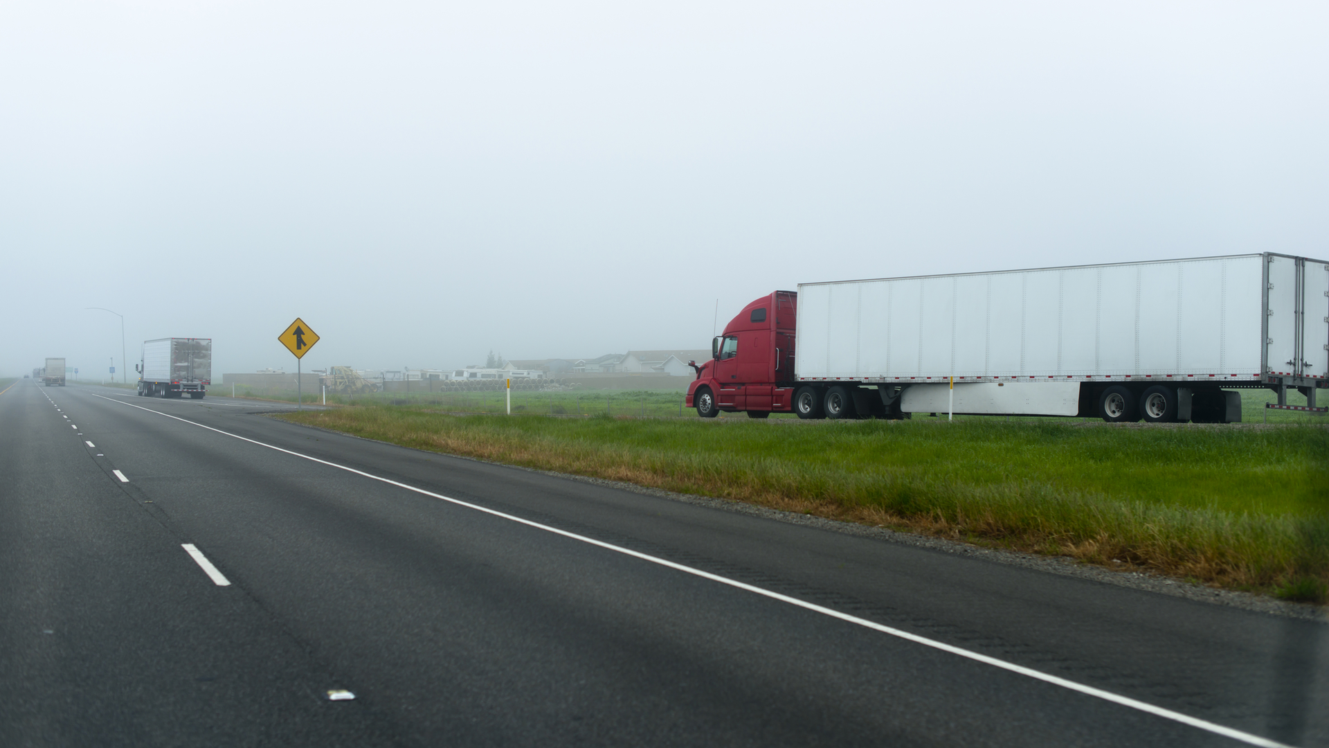A truck enters an interstate in California, disappearing into the fog.