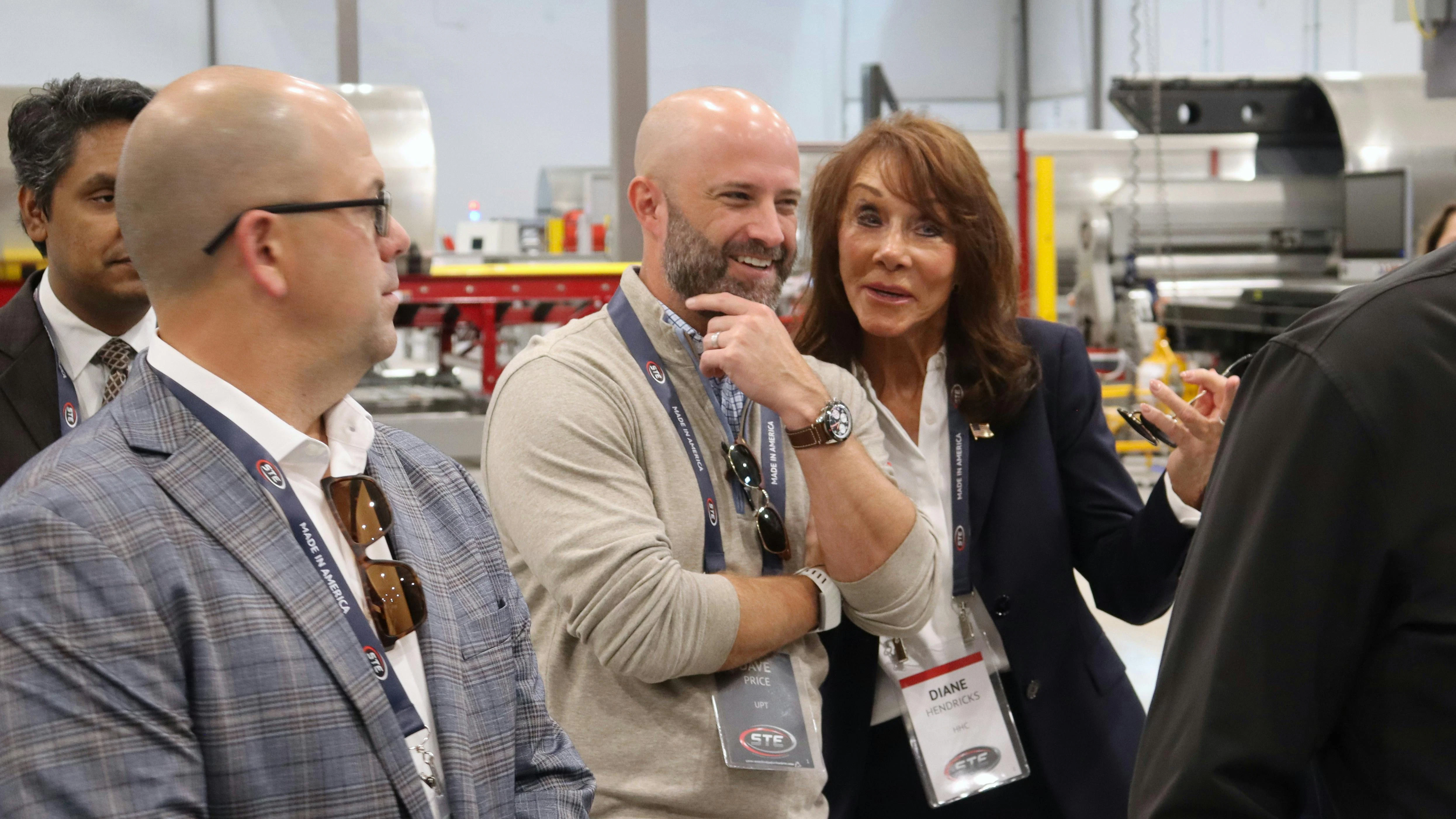 NTTC Chairman David Price, center, jokes with Hendricks Holding Chairman Diane Hendricks during a tour of STE's new trailing manufacturing facility.