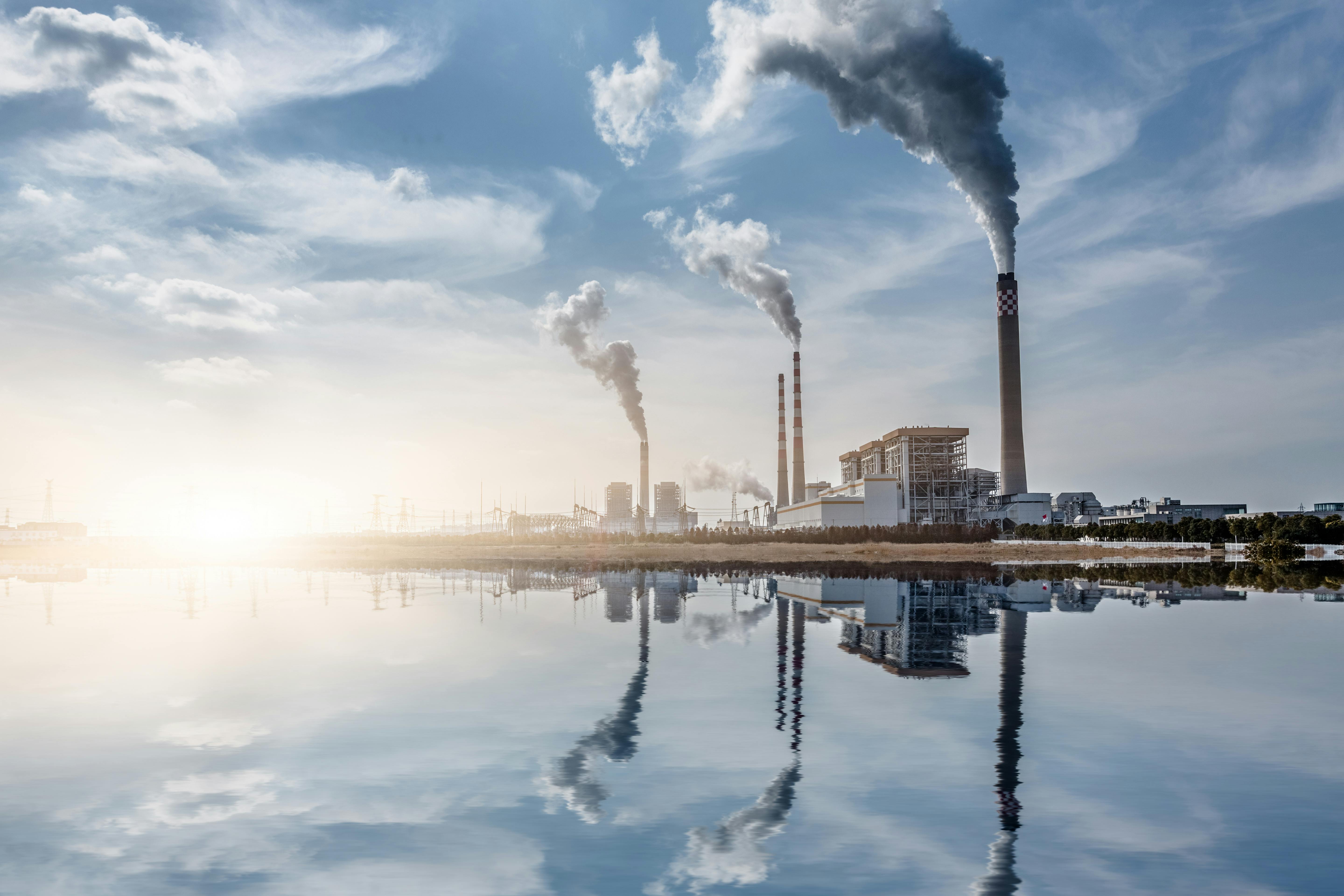 Chemical plant along waterfront against blue sky background