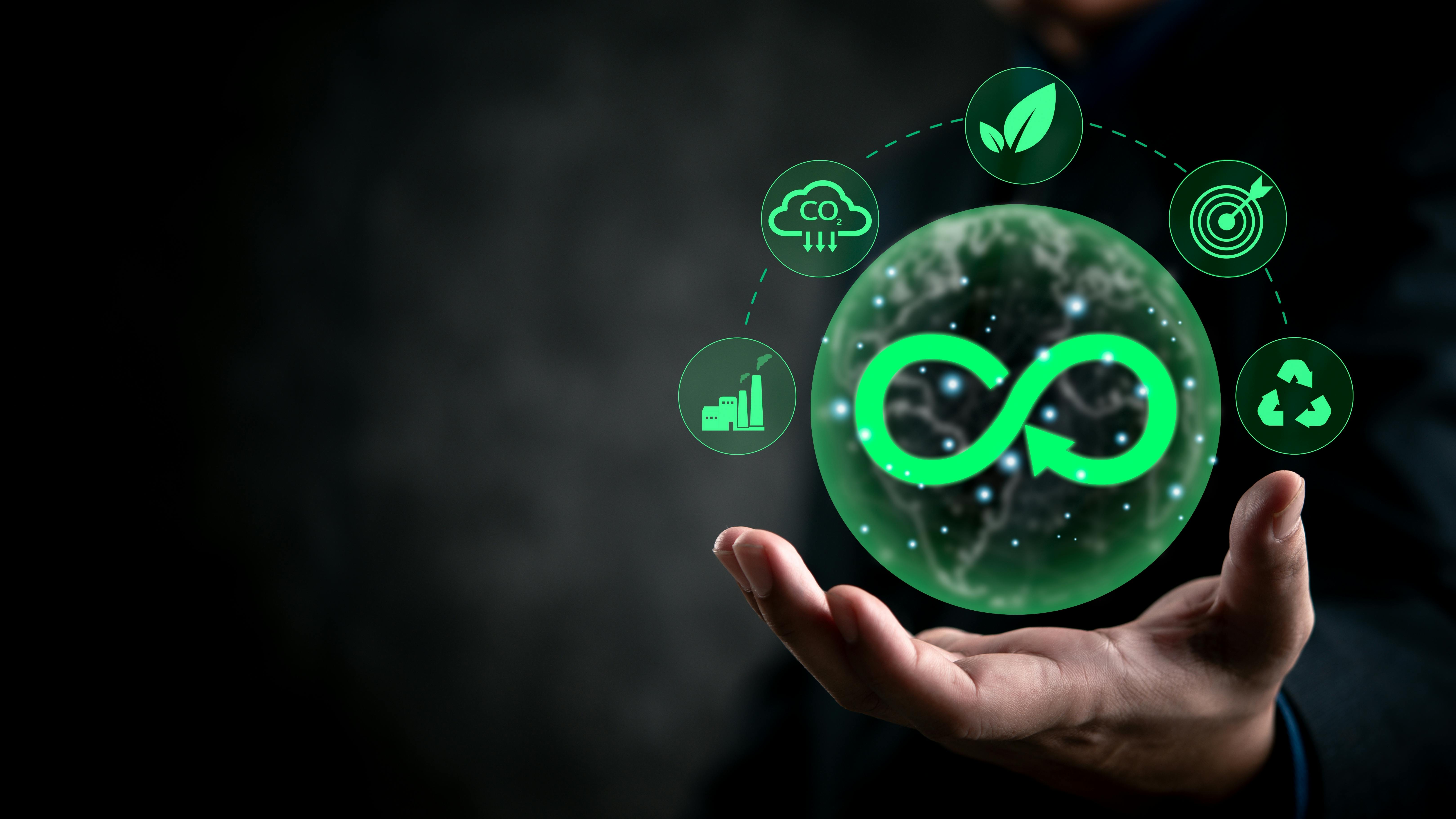 hand holding green circular economy icons on dark background