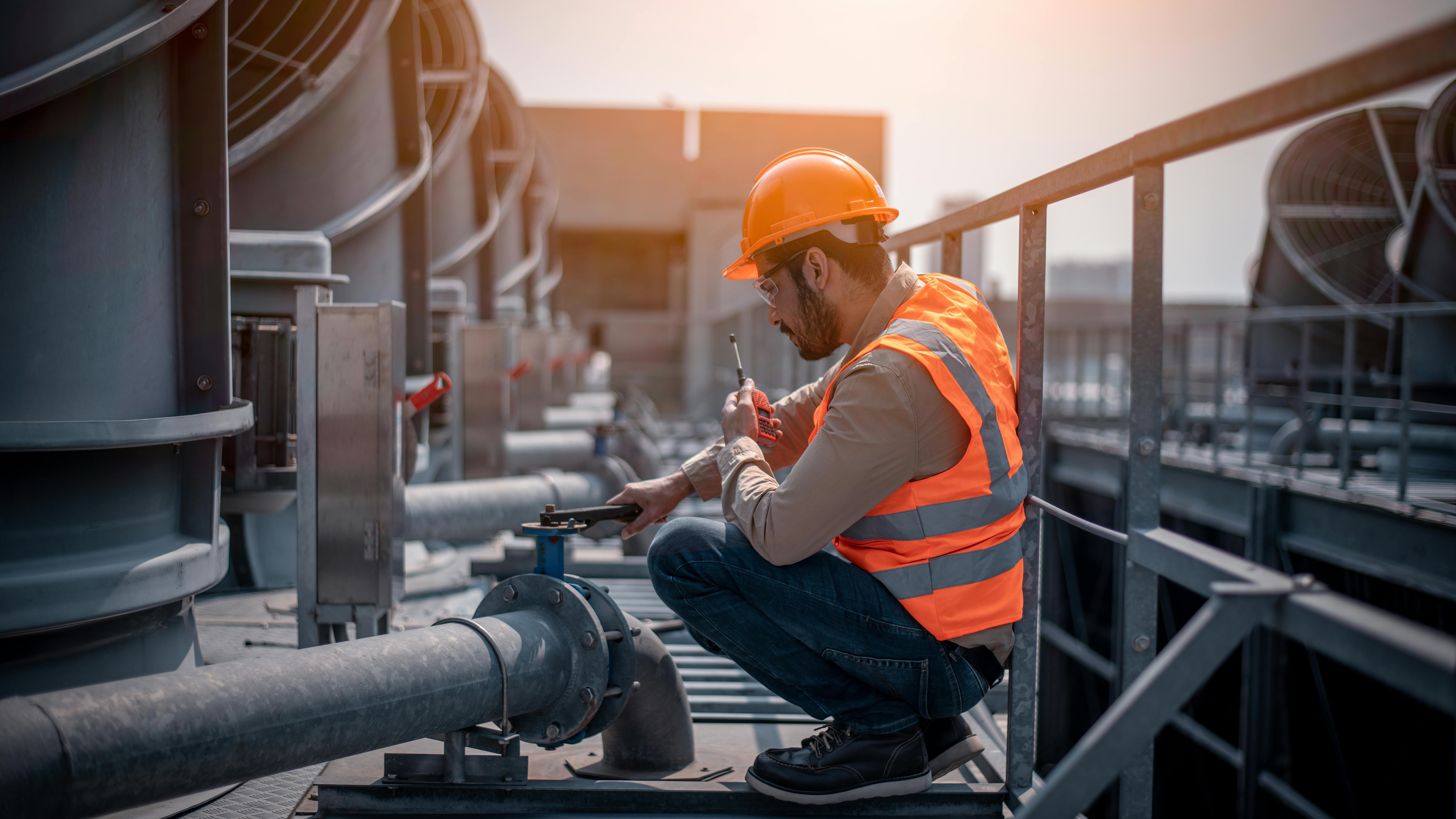 Industry engineer under checking the industry cooling tower air conditioner is water cooling tower air chiller HVAC of large industrial building to control air system.