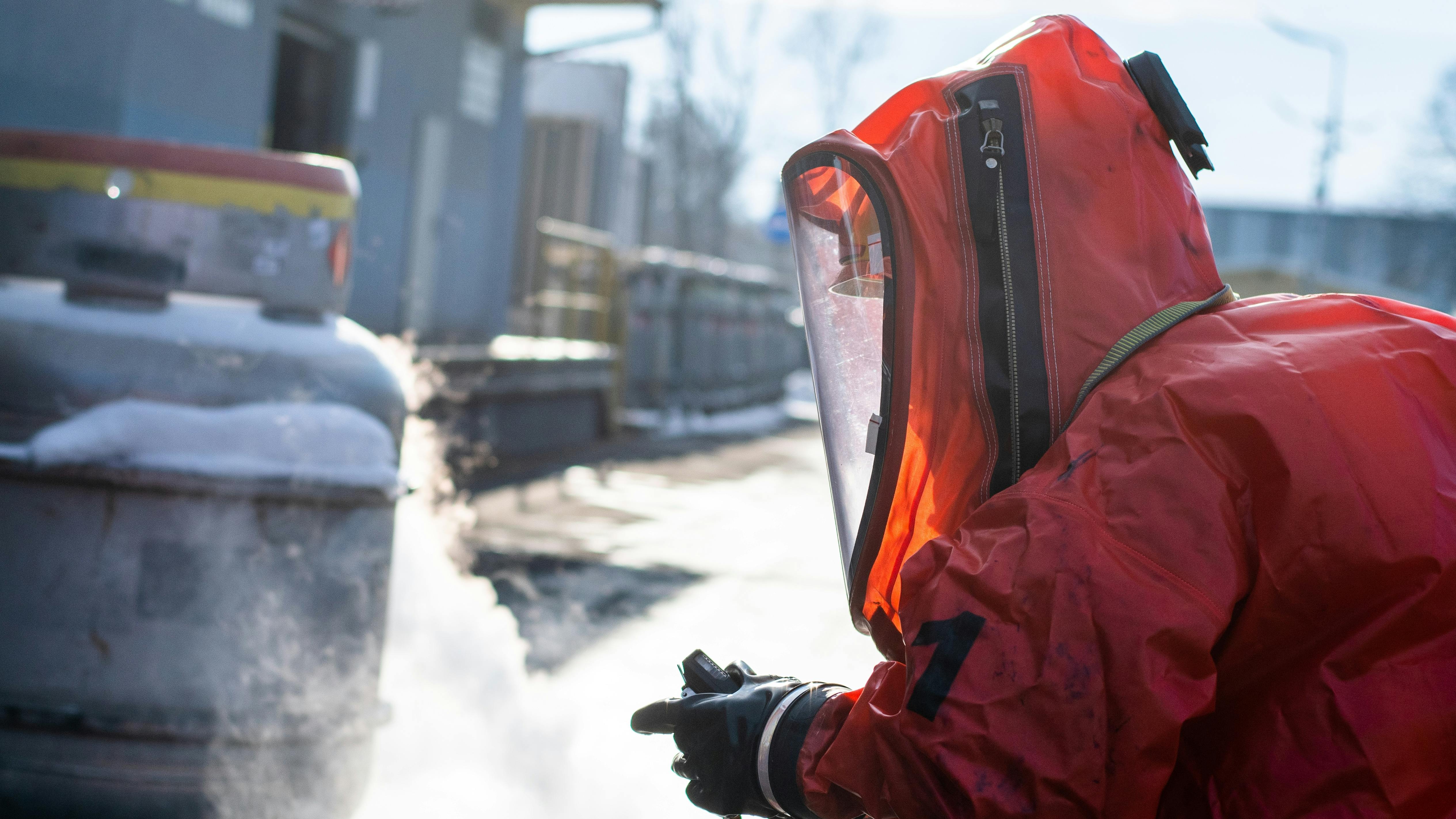 Firefighters in protective chemical HAZMAT suits stop chemical leak