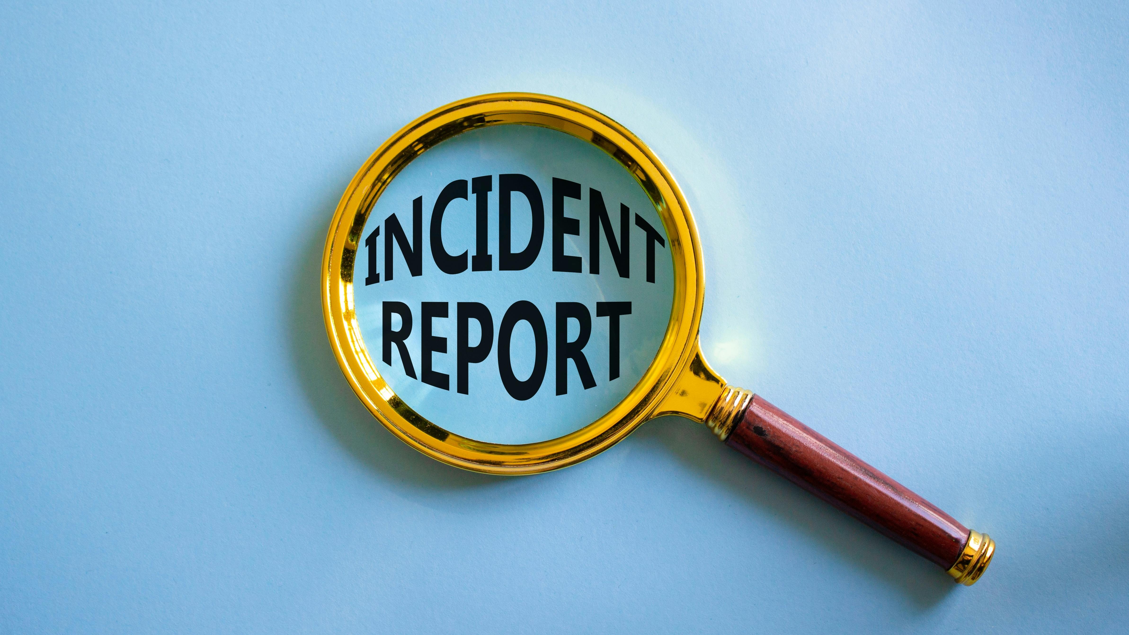 magnifying glass over the words incident report on blue background