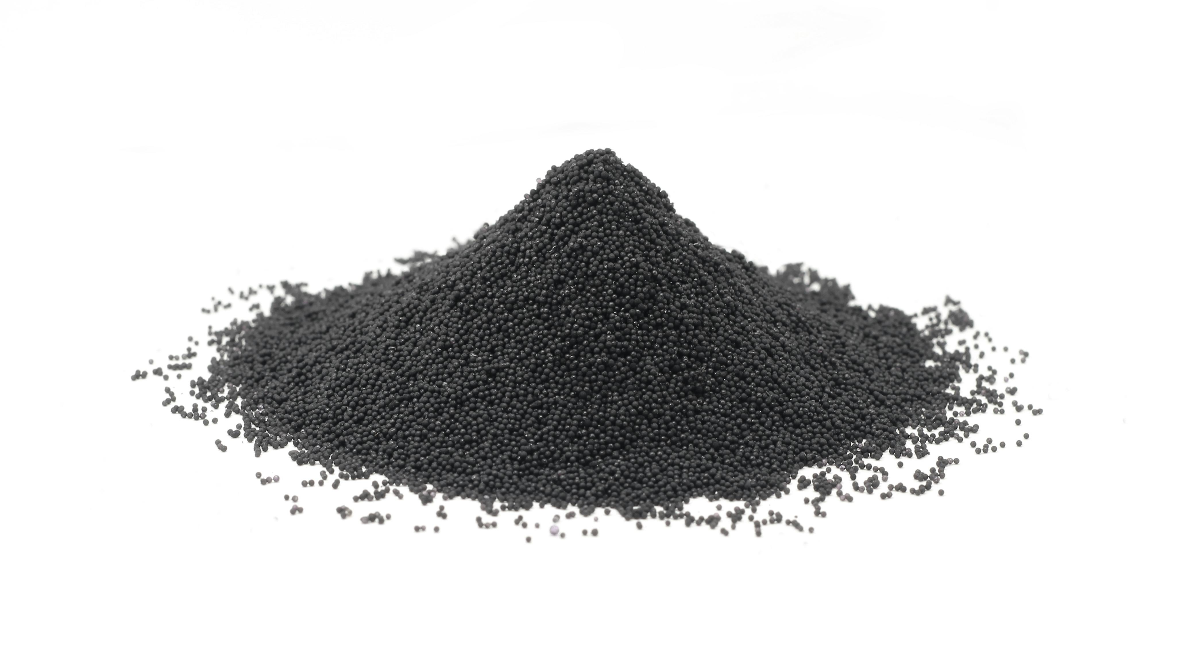 Handful of granular carbon powder on white background