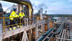 Two workers in safety gear stand on scaffold above Ineos acetyls plant in UK Two workers in safety gear stand on scaffold above Ineos acetyls plant in UK