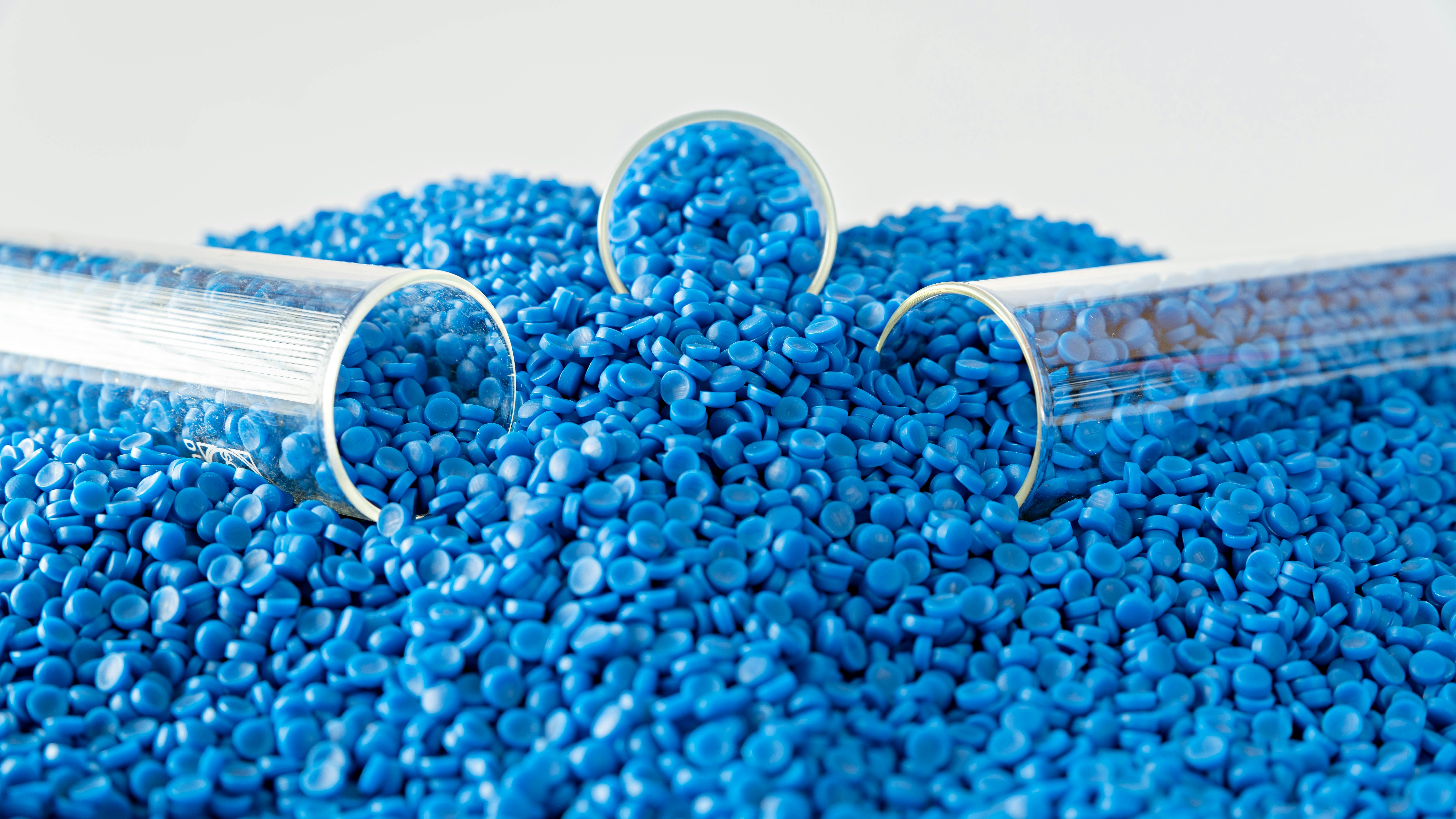 three test test tubes sit in pile of blue plastic pellets