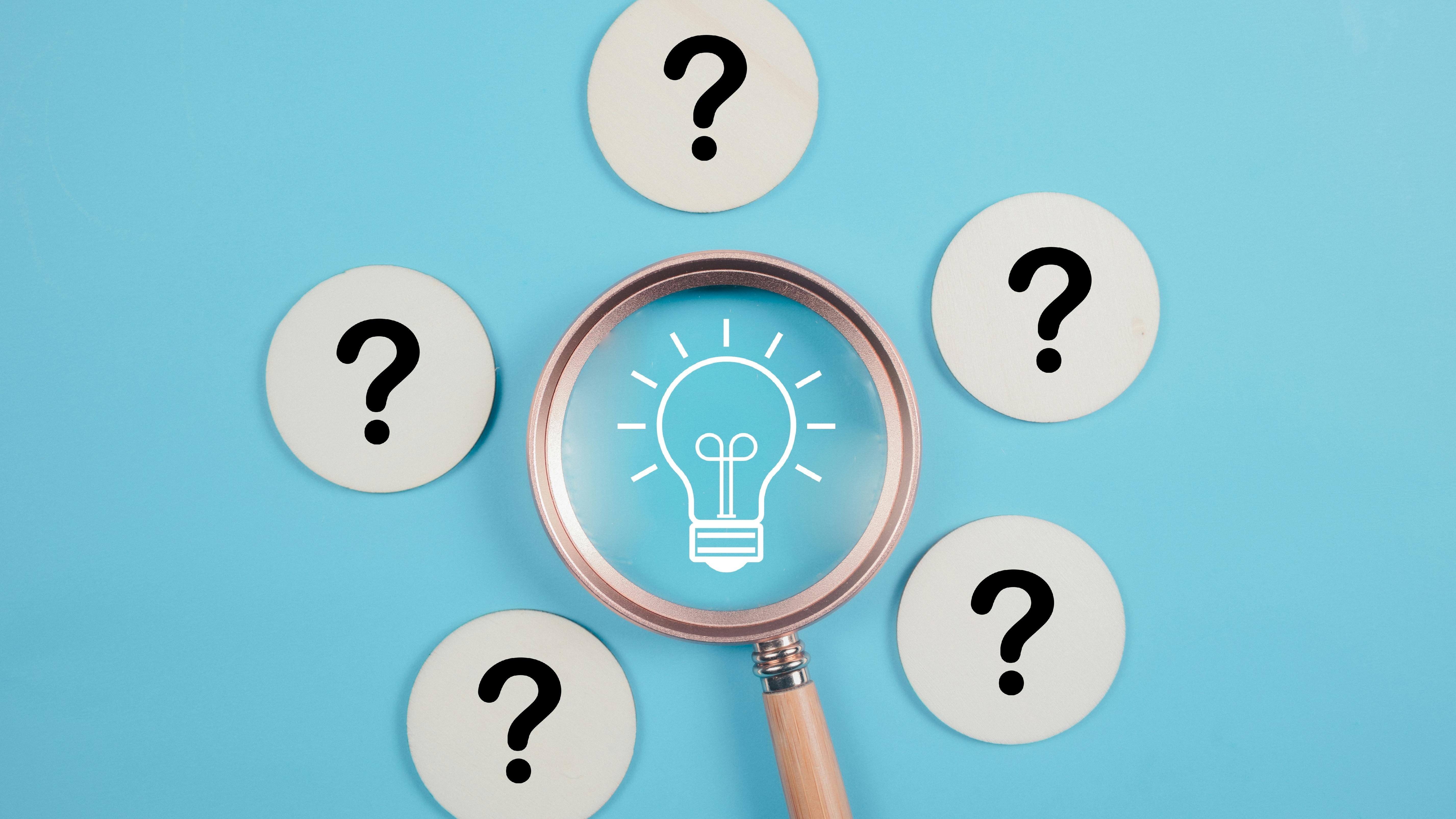 magnifying glass over image of light bulb surrounded by five question marks